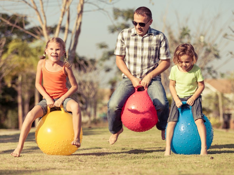 father and daughters playing