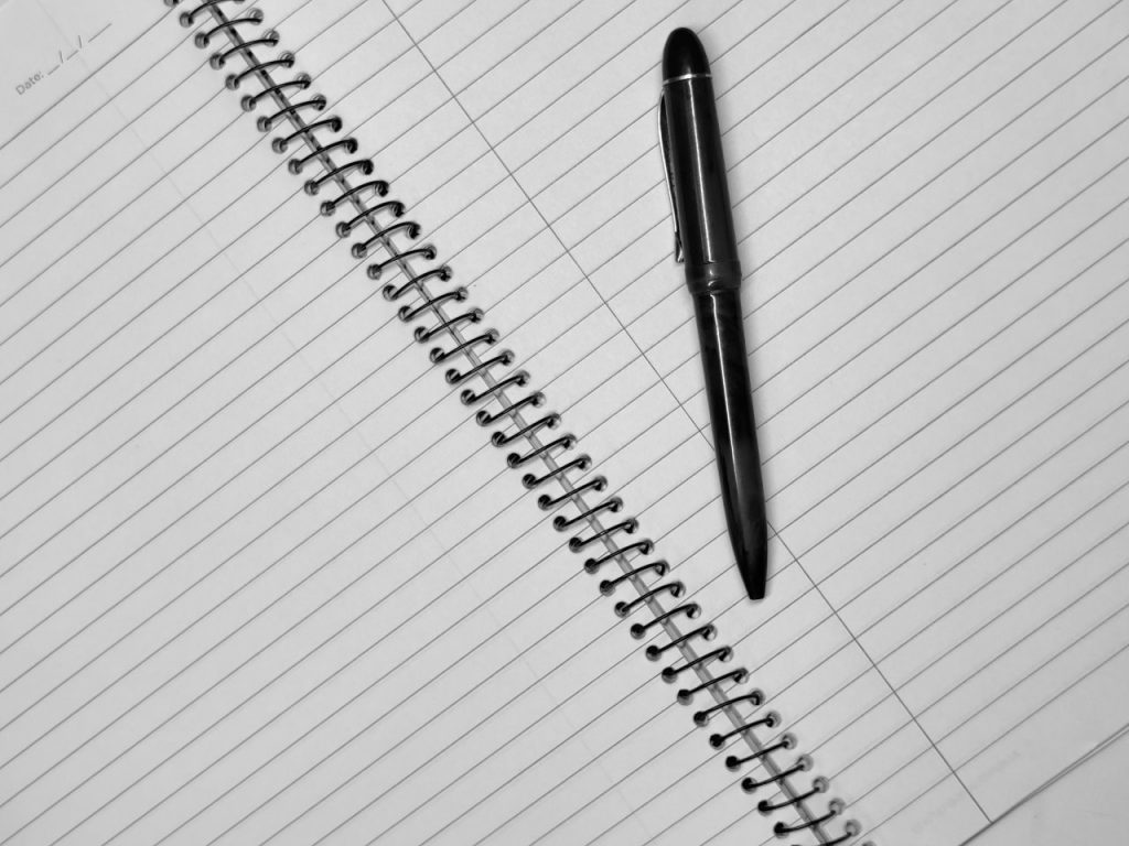 writer's block and procrastination pen and an empty notebook